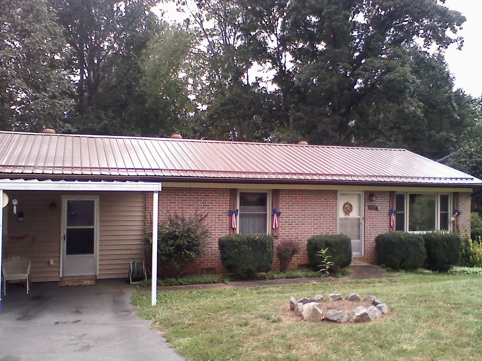 Bronze metal roof and carport on a brick ranch home — Roof Repair work by our crew in Theodore