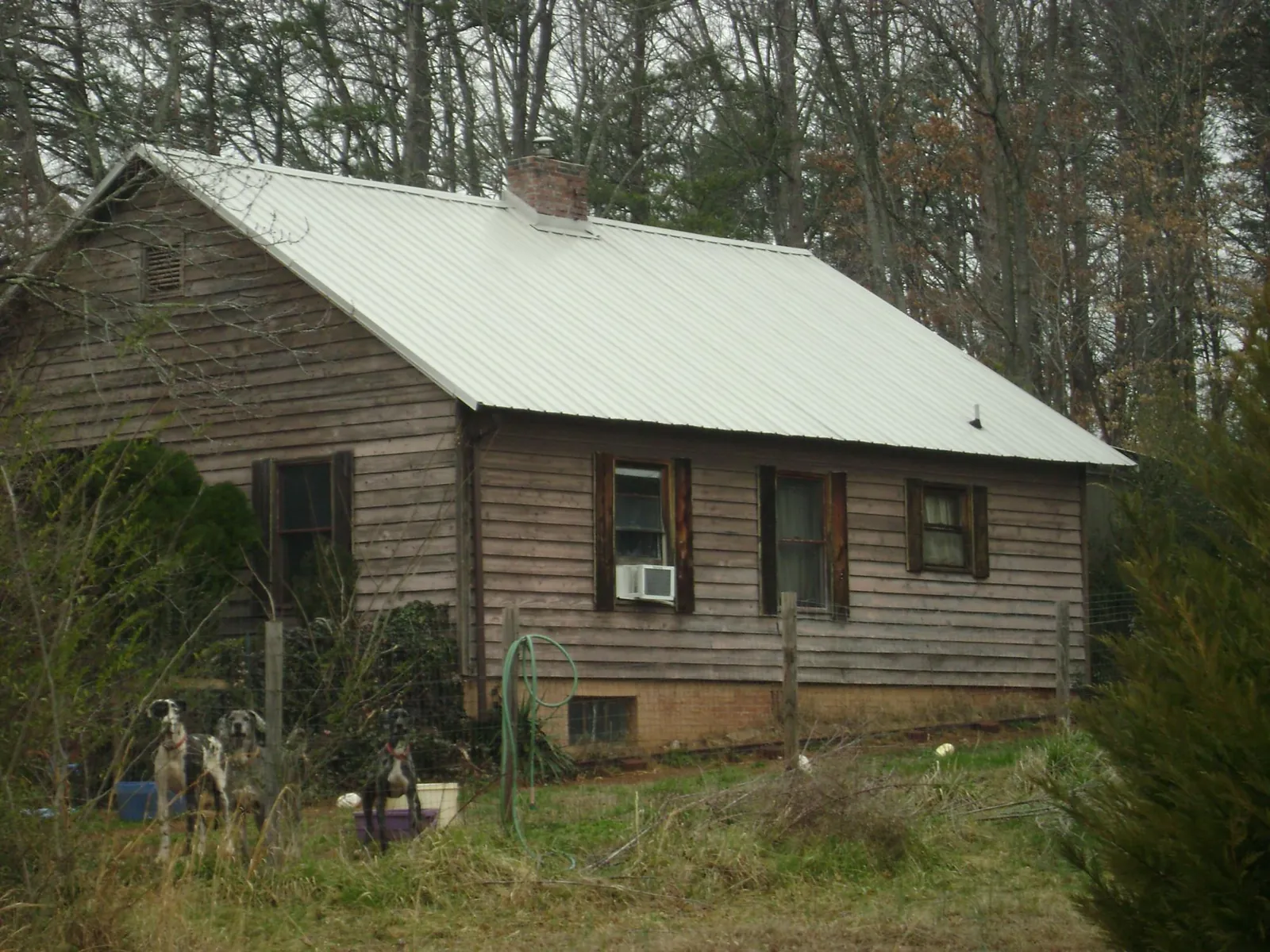 White metal roof on an old wood sided farmhouse, from a Metal Roof Installation job in Theodore